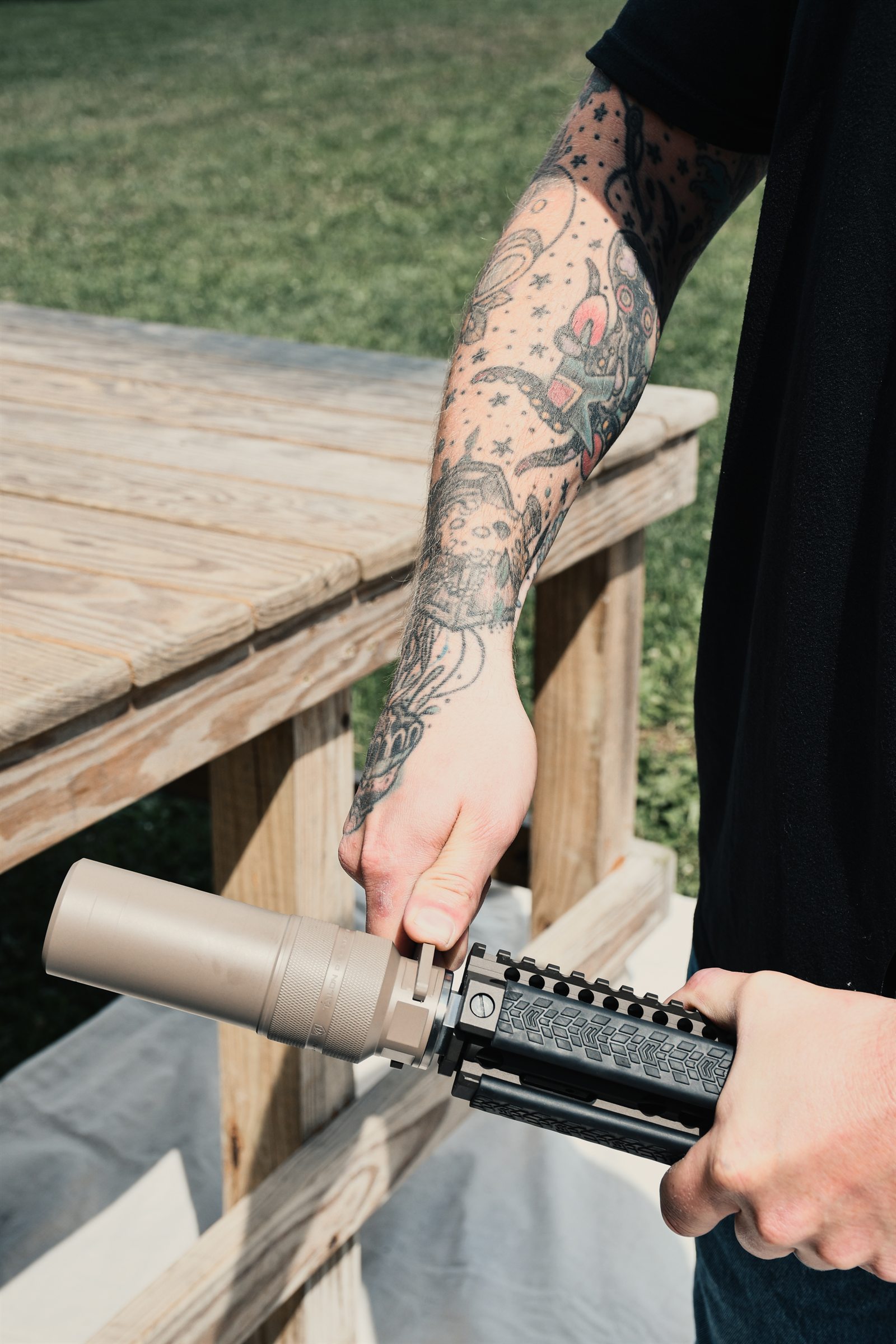 Hands threading a Diode onto a host rifle at the bench