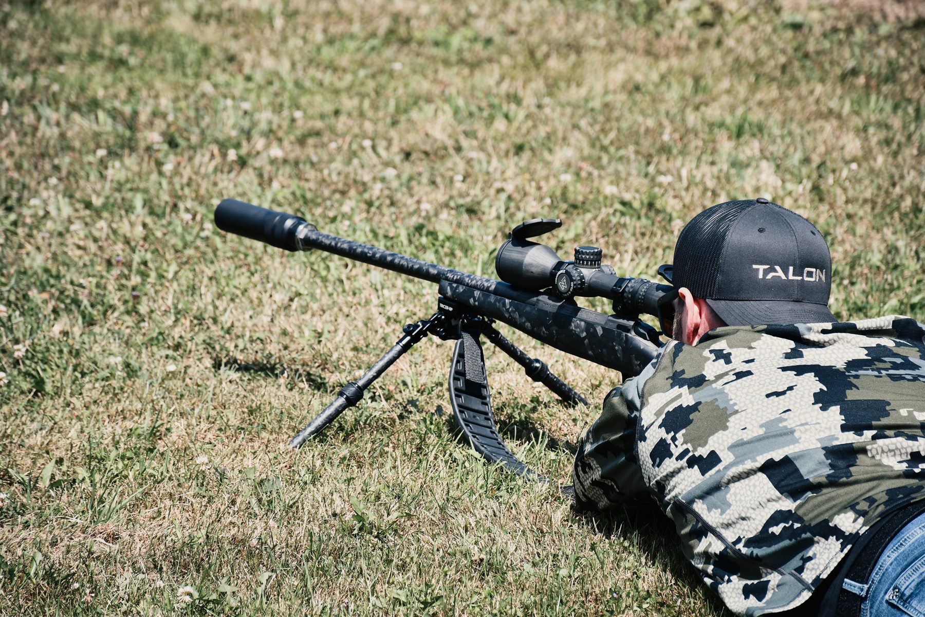 Shooter prone behind a Peregrine-equipped bolt-action rifle on a bipod