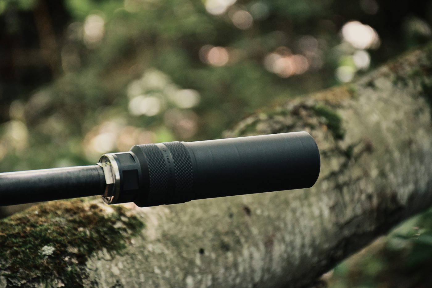 Peregrine suppressor on a carbon barrel resting on a mossy log